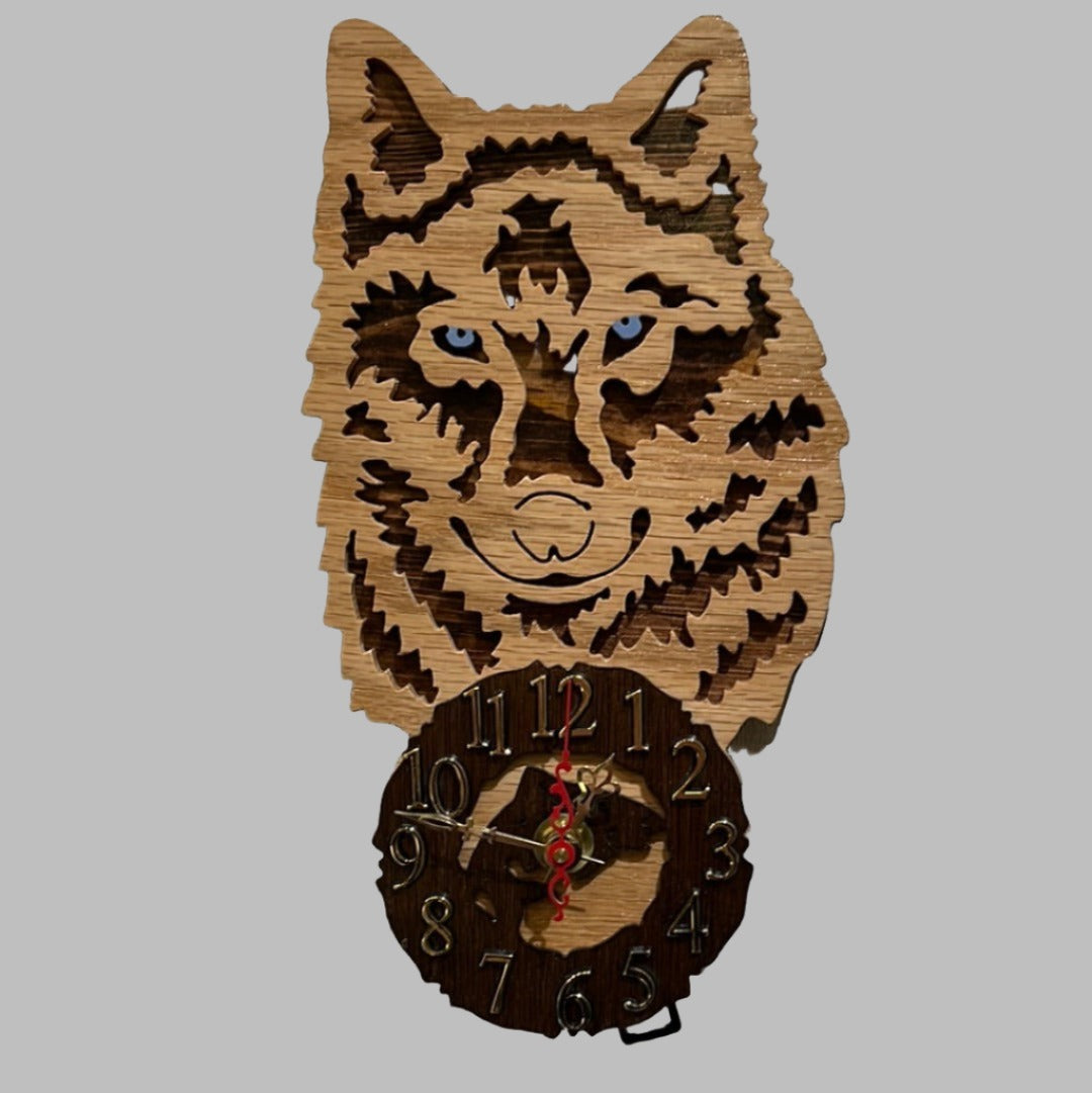 Wood wolf clock with howling wolf pendulum, hand scroll sawn, with high quality quartz movements, designed for years of service. One AA battery included. Certified Made in Alaska.